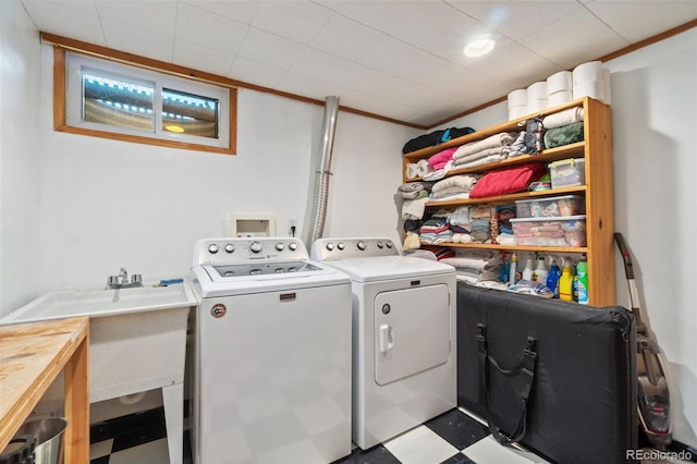 washroom featuring crown molding, washer and clothes dryer, and sink