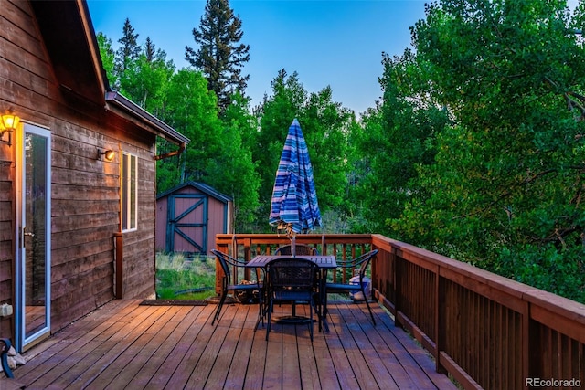 168 Mountain Vis, Como, CO 80432 - wooden deck featuring outdoor dining area, a storage unit, and view of scattered trees