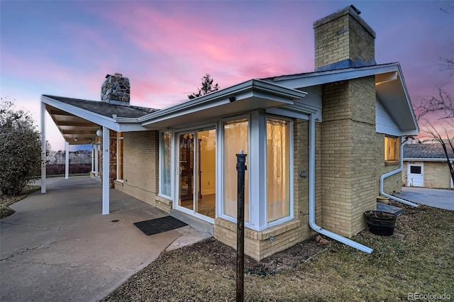 back house at dusk with a patio area