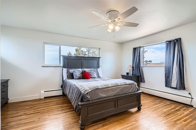 bedroom with ceiling fan, multiple windows, and a baseboard radiator