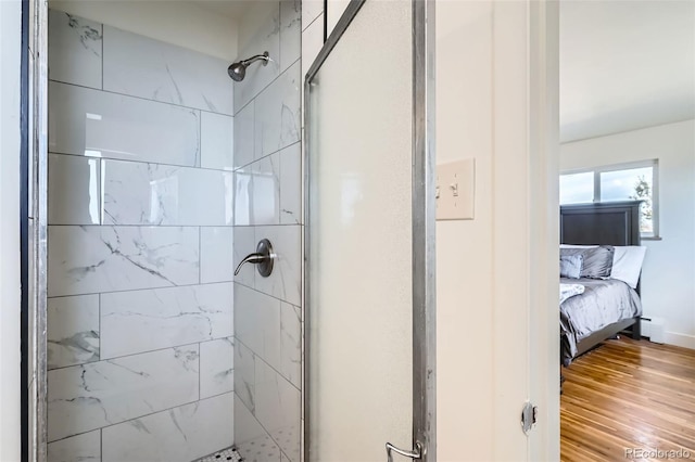 bathroom with wood-type flooring and a shower with shower door