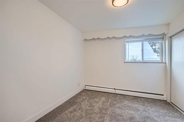 empty room with carpet flooring and baseboard heating