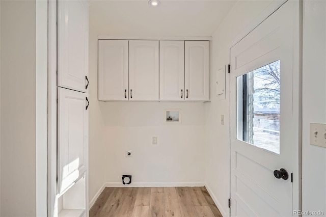 washroom with washer hookup, electric dryer hookup, light hardwood / wood-style floors, and cabinets