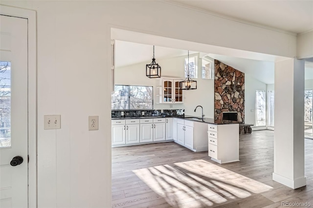 34 S Raleigh St, Denver, CO 80219 - kitchen featuring dark countertops, a peninsula, plenty of natural light, lofted ceiling, and light wood-type flooring