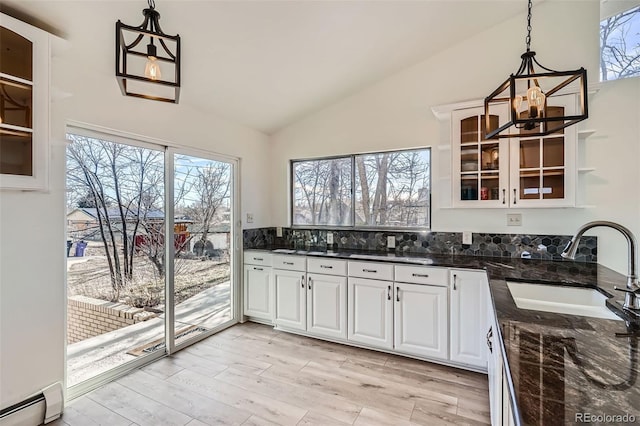 34 S Raleigh St, Denver, CO 80219 - kitchen featuring vaulted ceiling, a baseboard heating unit, white cabinetry, plenty of natural light, and glass insert cabinets