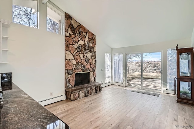 34 S Raleigh St, Denver, CO 80219 - unfurnished living room featuring a stone fireplace, a baseboard radiator, high vaulted ceiling, and wood finished floors