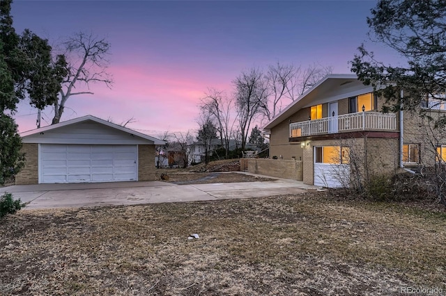 34 S Raleigh St, Denver, CO 80219 - property exterior at dusk featuring brick siding, a balcony, and concrete driveway