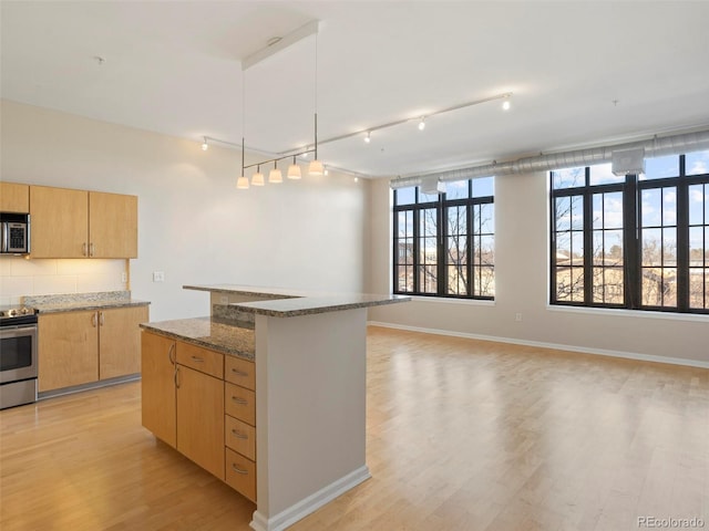 kitchen featuring a center island, stainless steel appliances, stone countertops, and light hardwood / wood-style floors