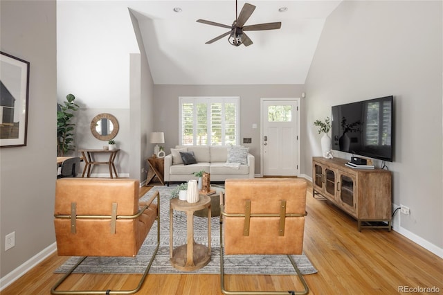 living room with baseboards, high vaulted ceiling, ceiling fan, and wood finished floors