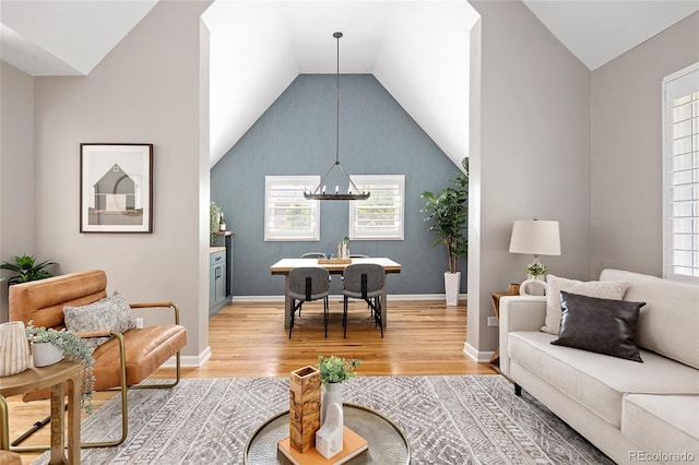 living area with light wood-style flooring, plenty of natural light, and lofted ceiling