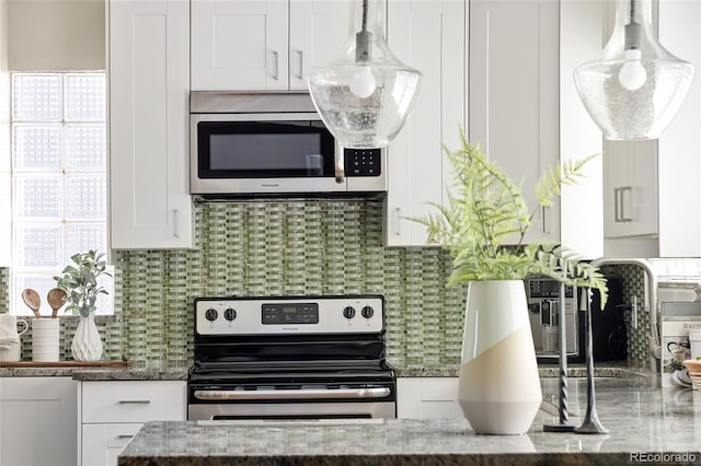 kitchen featuring dark stone countertops, white cabinetry, stainless steel appliances, and tasteful backsplash