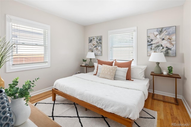 bedroom with light wood-style flooring and baseboards