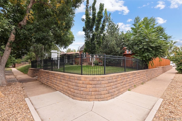 view of property's community featuring a lawn and fence