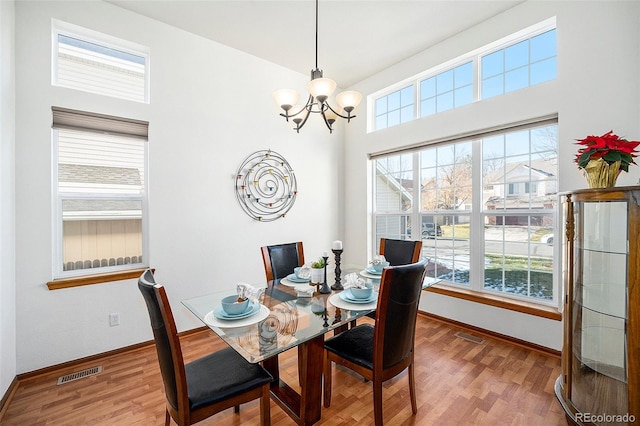 dining space featuring a chandelier, wood-type flooring, and a wealth of natural light