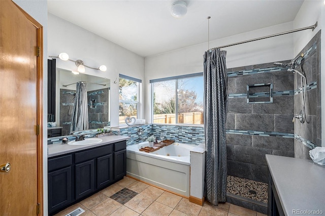 bathroom featuring plus walk in shower, vanity, and tile patterned floors