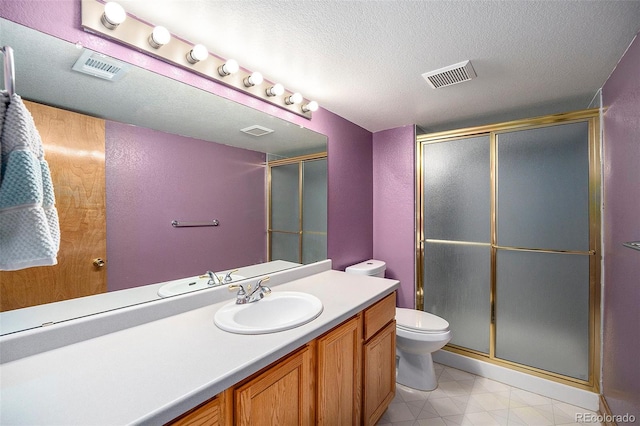 bathroom with vanity, a shower with shower door, a textured ceiling, and toilet