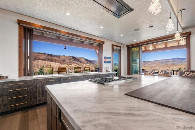 5188 Csh 125, Granby, CO 80446 - kitchen with stainless steel gas cooktop, dark brown cabinetry, a mountain view, hanging light fixtures, and recessed lighting
