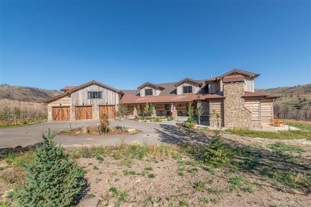 5188 Csh 125, Granby, CO 80446 - view of front of home featuring stone siding, concrete driveway, a garage, and board and batten siding