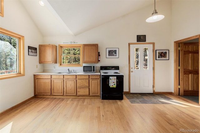 3581 Gap Rd, Golden, CO 80403 - kitchen with range with electric cooktop, stainless steel microwave, a sink, high vaulted ceiling, and light countertops