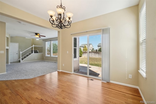 interior space featuring hardwood / wood-style floors and ceiling fan with notable chandelier