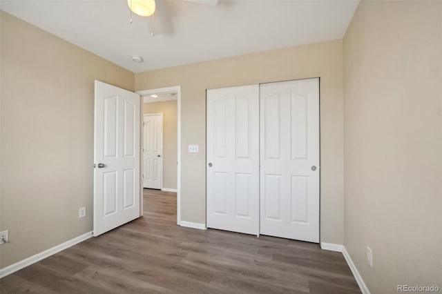 unfurnished bedroom featuring ceiling fan, dark wood-type flooring, and a closet