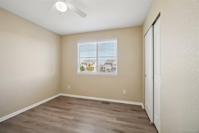 unfurnished bedroom with a closet, ceiling fan, and hardwood / wood-style floors