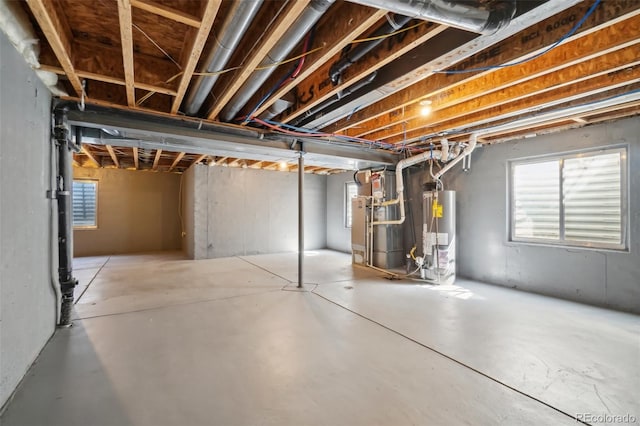 basement featuring heating unit, water heater, and plenty of natural light