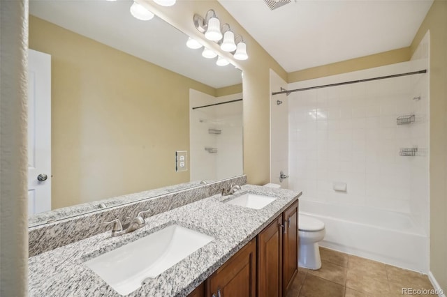 full bathroom featuring tile patterned flooring, vanity, tiled shower / bath combo, and toilet