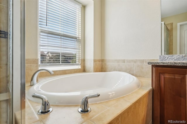 bathroom with shower with separate bathtub, vanity, and a healthy amount of sunlight