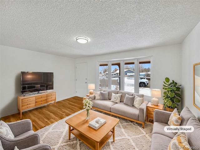 living room with a textured ceiling and wood finished floors