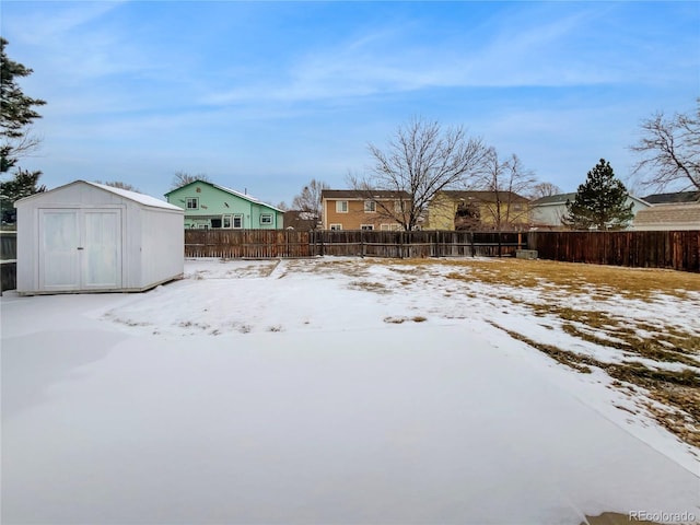 yard layered in snow featuring a shed