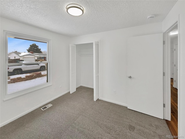 carpeted bedroom featuring a textured ceiling and a closet