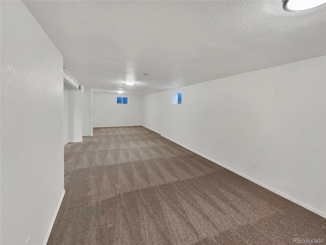 basement with carpet and a textured ceiling