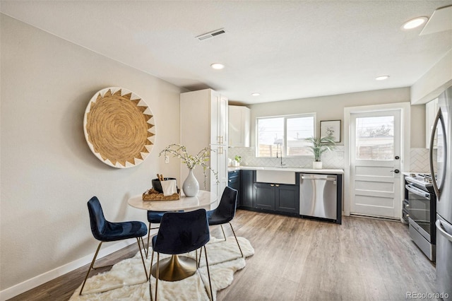 dining area with sink and light hardwood / wood-style flooring