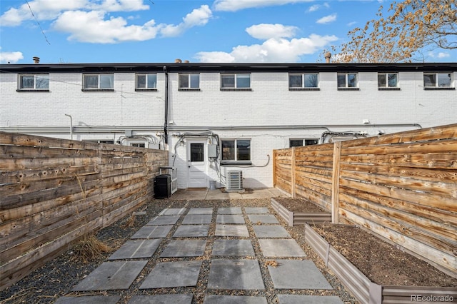 rear view of property featuring central AC unit and a patio area