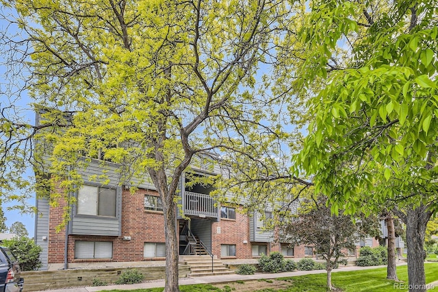 3558 S Depew St Unit 302, Denver, CO 80235 - view of front of home featuring brick siding, stairway, and a front yard