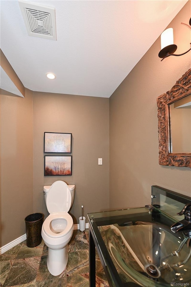 1502 Columbine Ave, Boulder, CO 80302 - bathroom with toilet, baseboards, recessed lighting, a sink, and stone finish floors