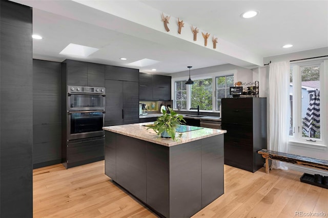 1502 Columbine Ave, Boulder, CO 80302 - kitchen featuring a skylight, modern cabinets, light wood-style flooring, double wall oven, and pendant lighting