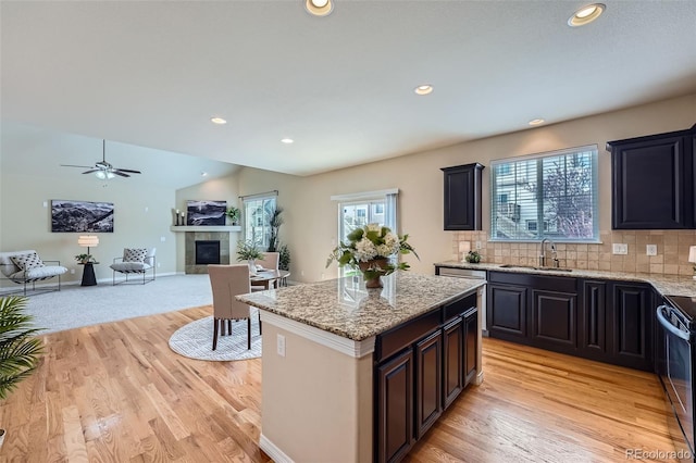 kitchen with a kitchen island, recessed lighting, black electric range oven, and a sink