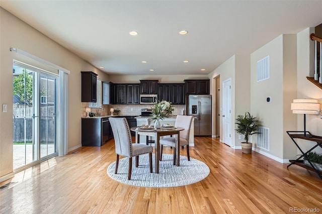 dining space featuring light wood-style floors and visible vents