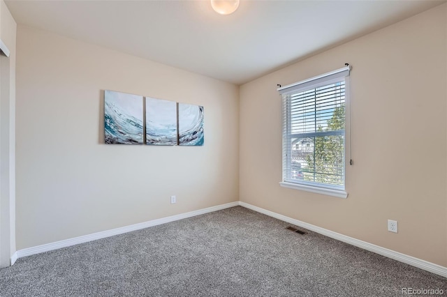 carpeted spare room featuring baseboards and visible vents