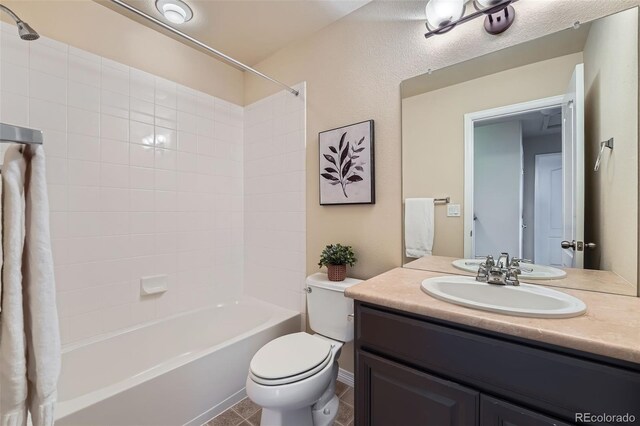 bathroom with washtub / shower combination, vanity, and toilet