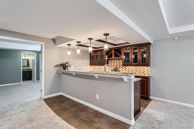 kitchen featuring a peninsula, dark brown cabinetry, a breakfast bar, and glass insert cabinets