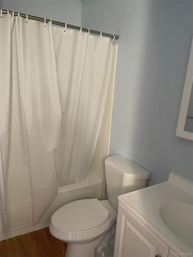 full bathroom featuring shower / tub combo with curtain, hardwood / wood-style floors, vanity, and toilet