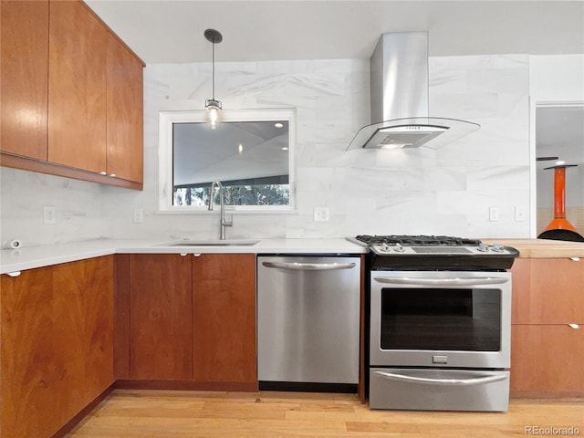 kitchen with decorative light fixtures, backsplash, range hood, sink, and stainless steel appliances