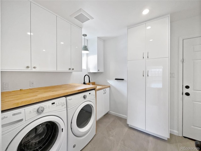 laundry room featuring cabinets, sink, washing machine and dryer, and light tile patterned flooring