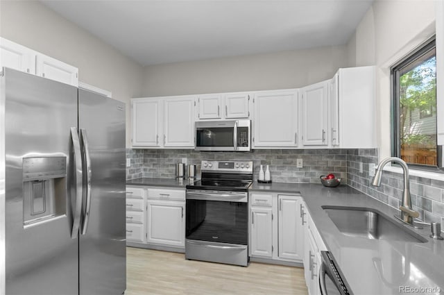 10693 W 63rd Dr Unit 106, Arvada, CO 80004 - kitchen with stainless steel appliances, a sink, white cabinetry, and decorative backsplash
