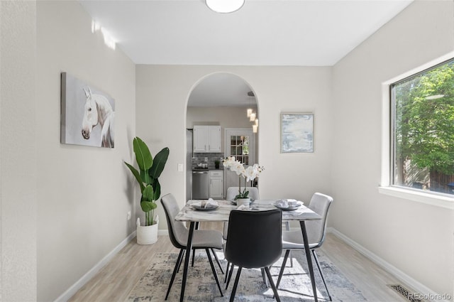 10693 W 63rd Dr Unit 106, Arvada, CO 80004 - dining space featuring healthy amount of natural light, light wood-type flooring, and arched walkways