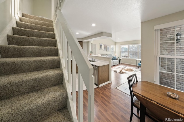 stairway featuring sink and hardwood / wood-style floors