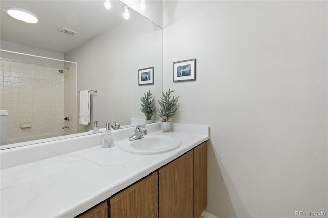 bathroom featuring tiled shower / bath combo and vanity